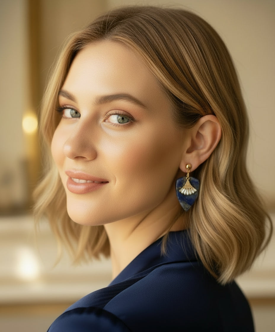 Woman wearing blue earrings with a blurred indoor background