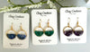 Three pairs of earrings on 'Clay Couture' cards with floral background